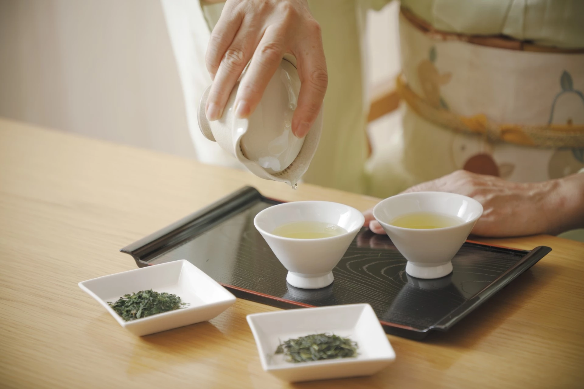 a person pouring liquid into small bowls