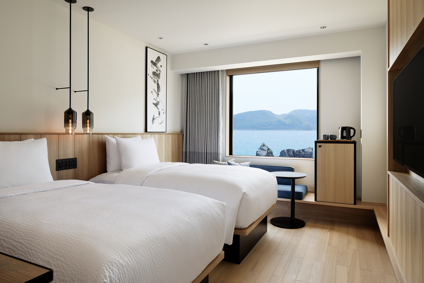 a room with two beds and a window overlooking the water