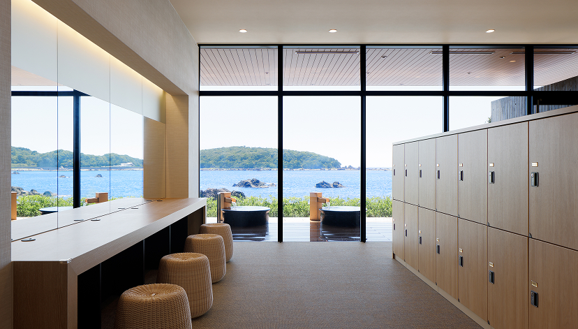a room with lockers and chairs and a view of the ocean