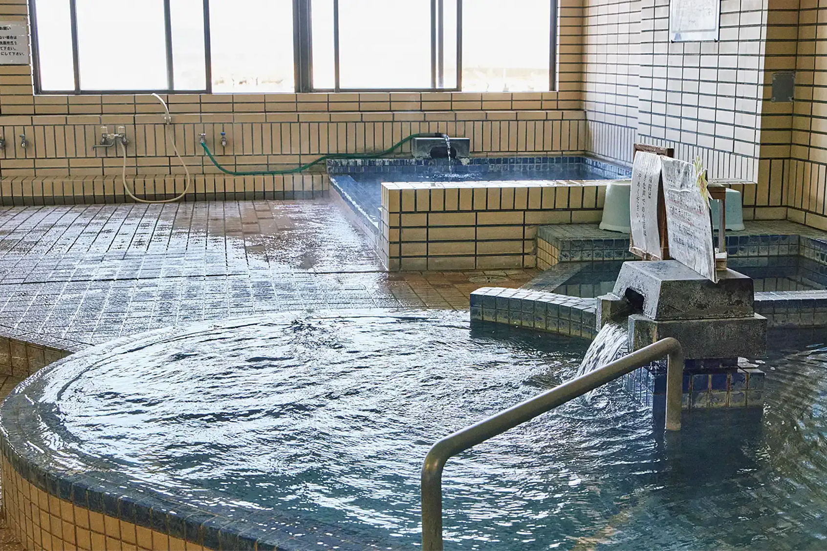 a large indoor hot tub with water running down the ground