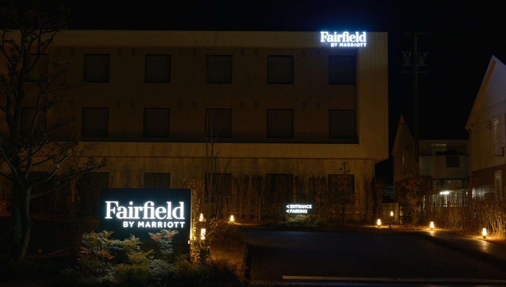a building with a sign and a parking lot