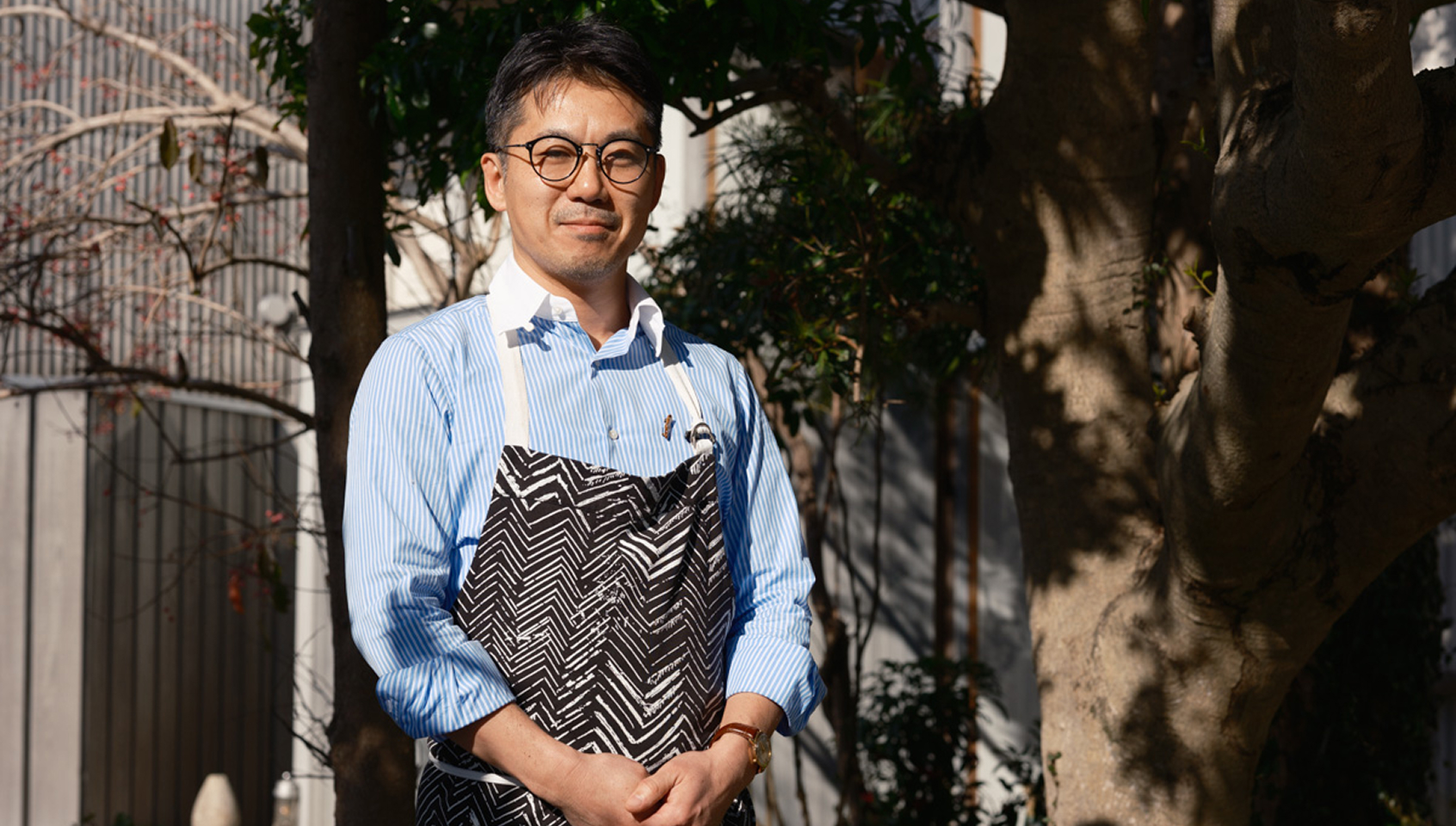 a man wearing glasses and a striped shirt