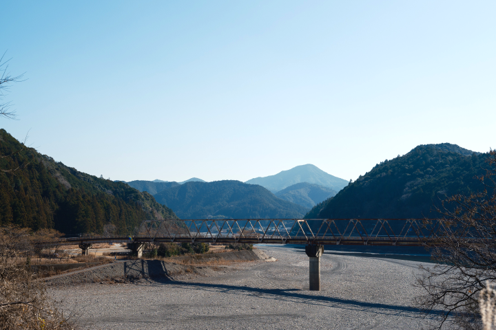 a bridge over a road with mountains in the background