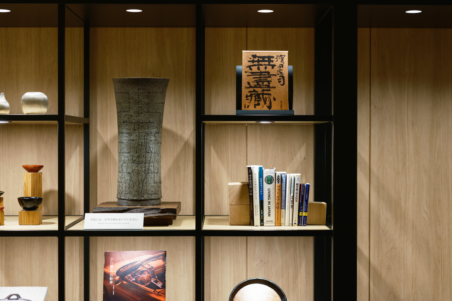 a shelf with books and a vase on it