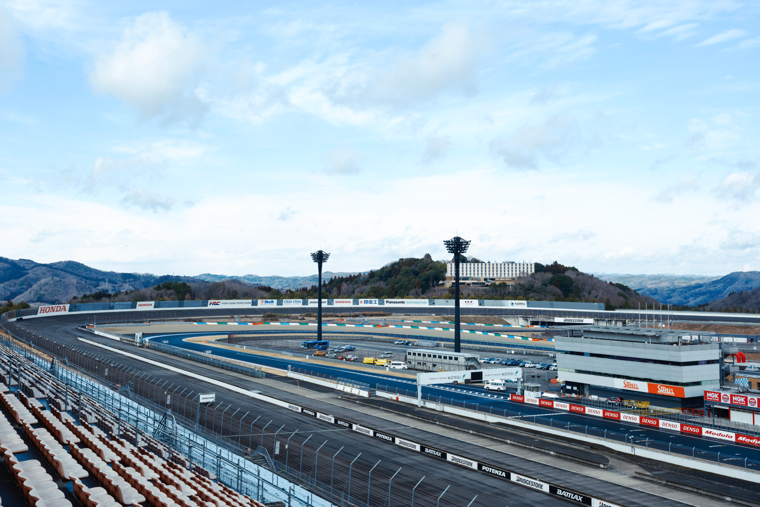 a race track with a fence and a building