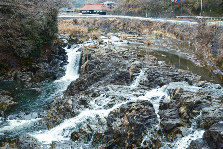 a river with rocks and a bridge