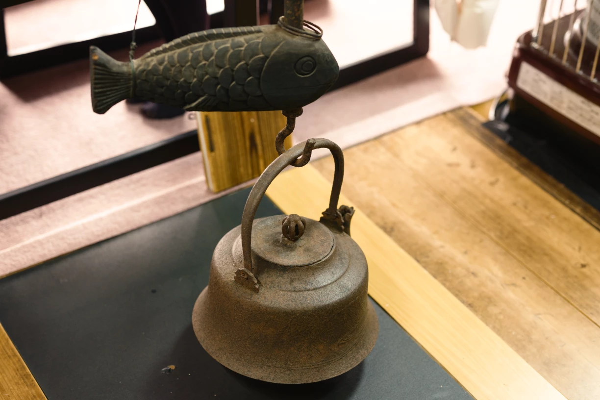 a metal fish on a kettle