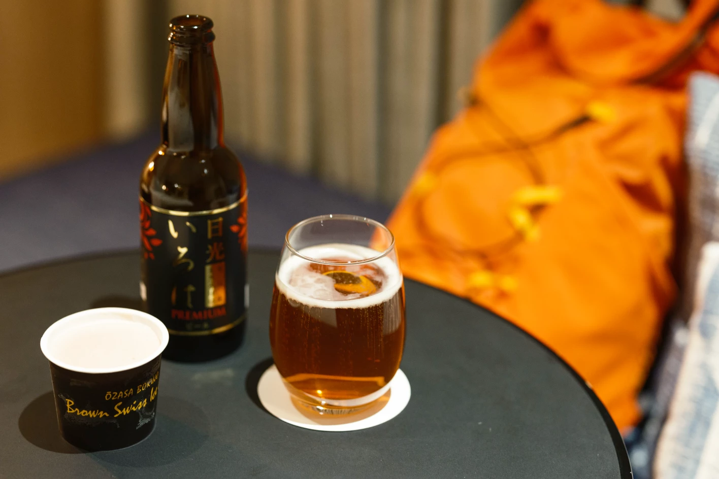 a glass of beer and a bottle on a table