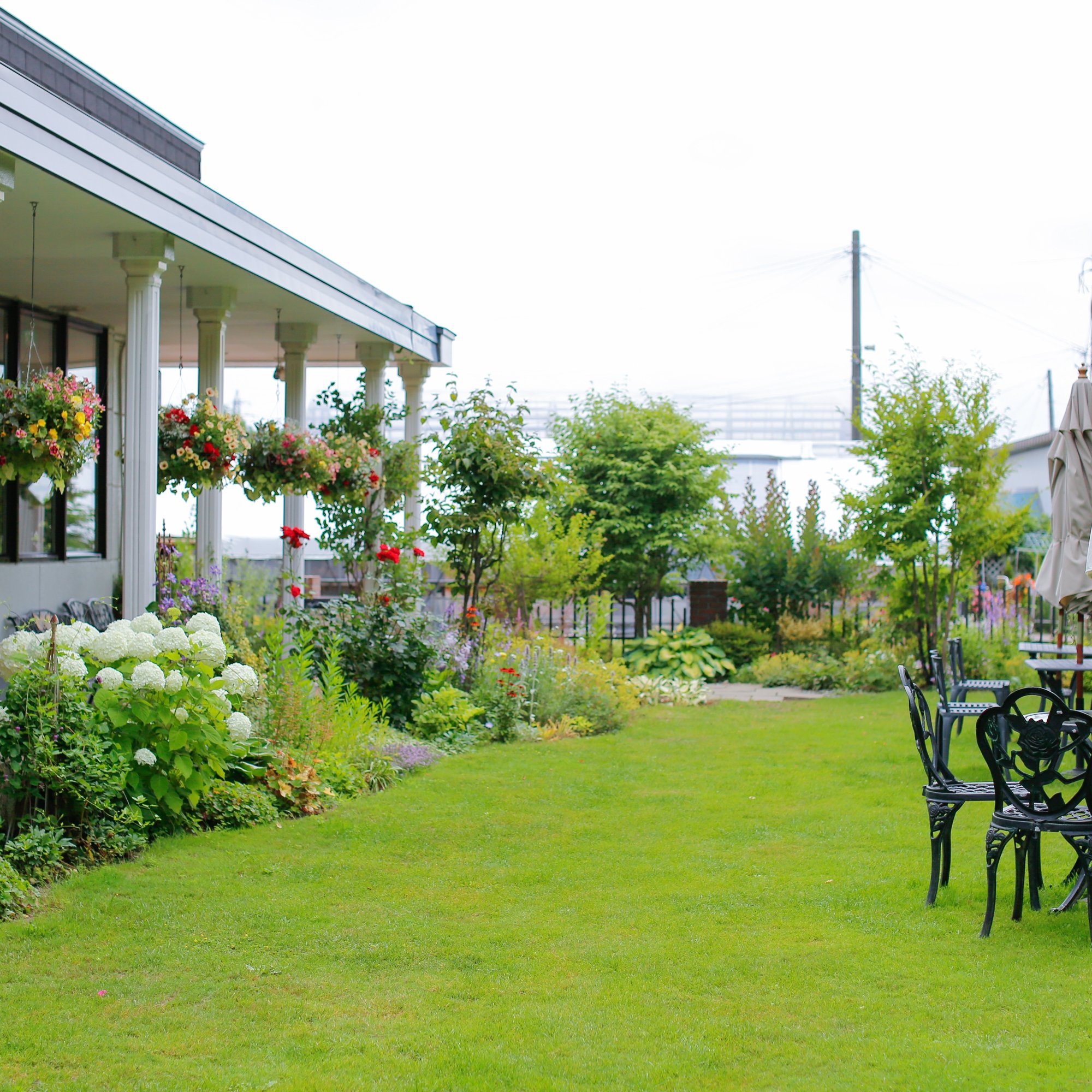a lawn with chairs and tables in front of a house