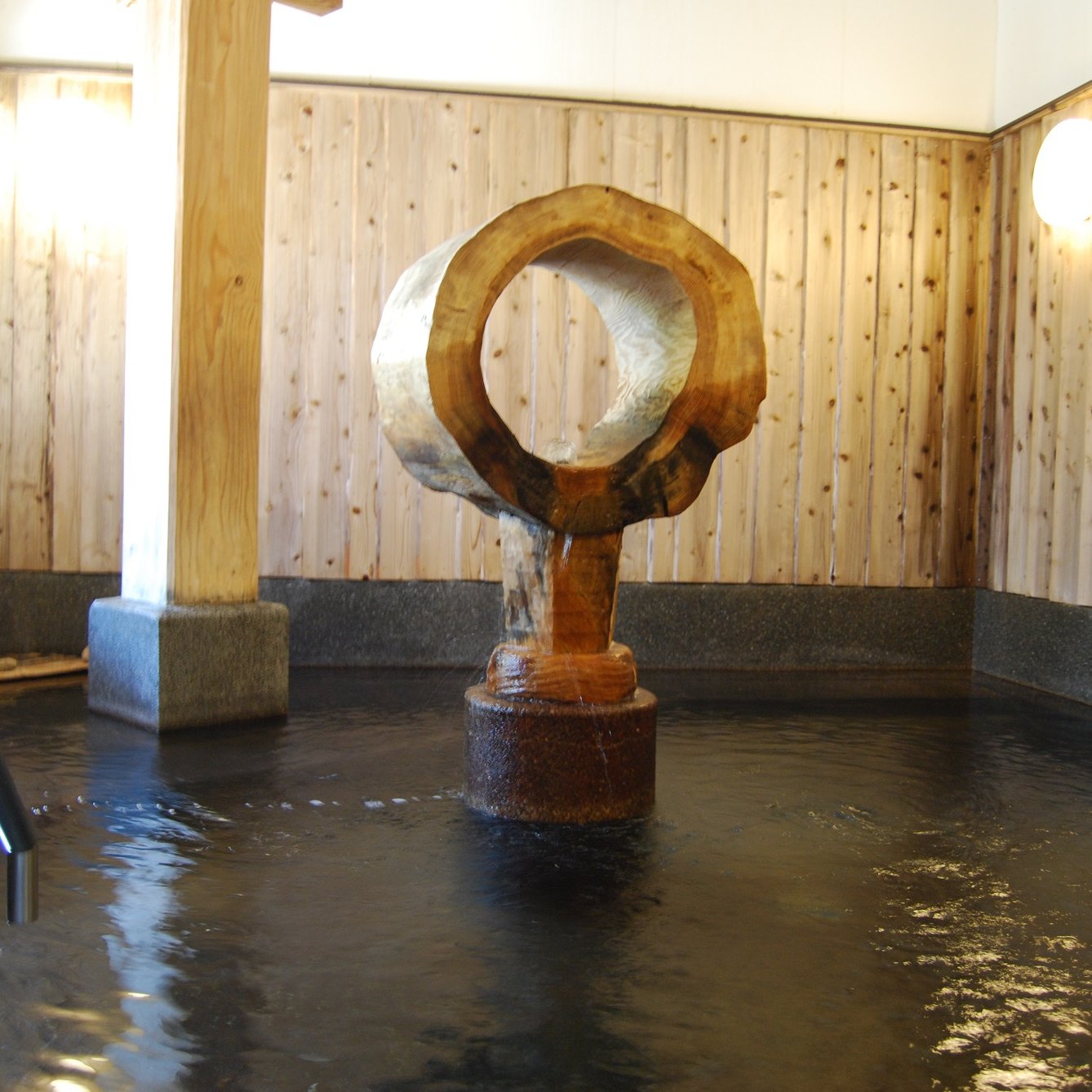 a wooden sculpture in a pool of water