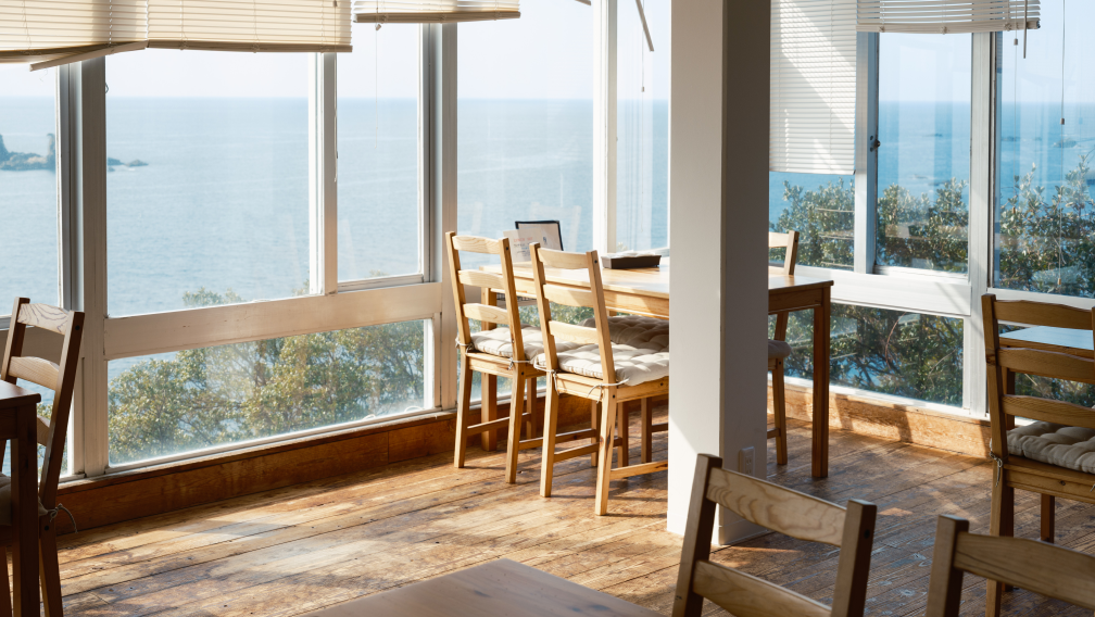 a room with a table and chairs by the window