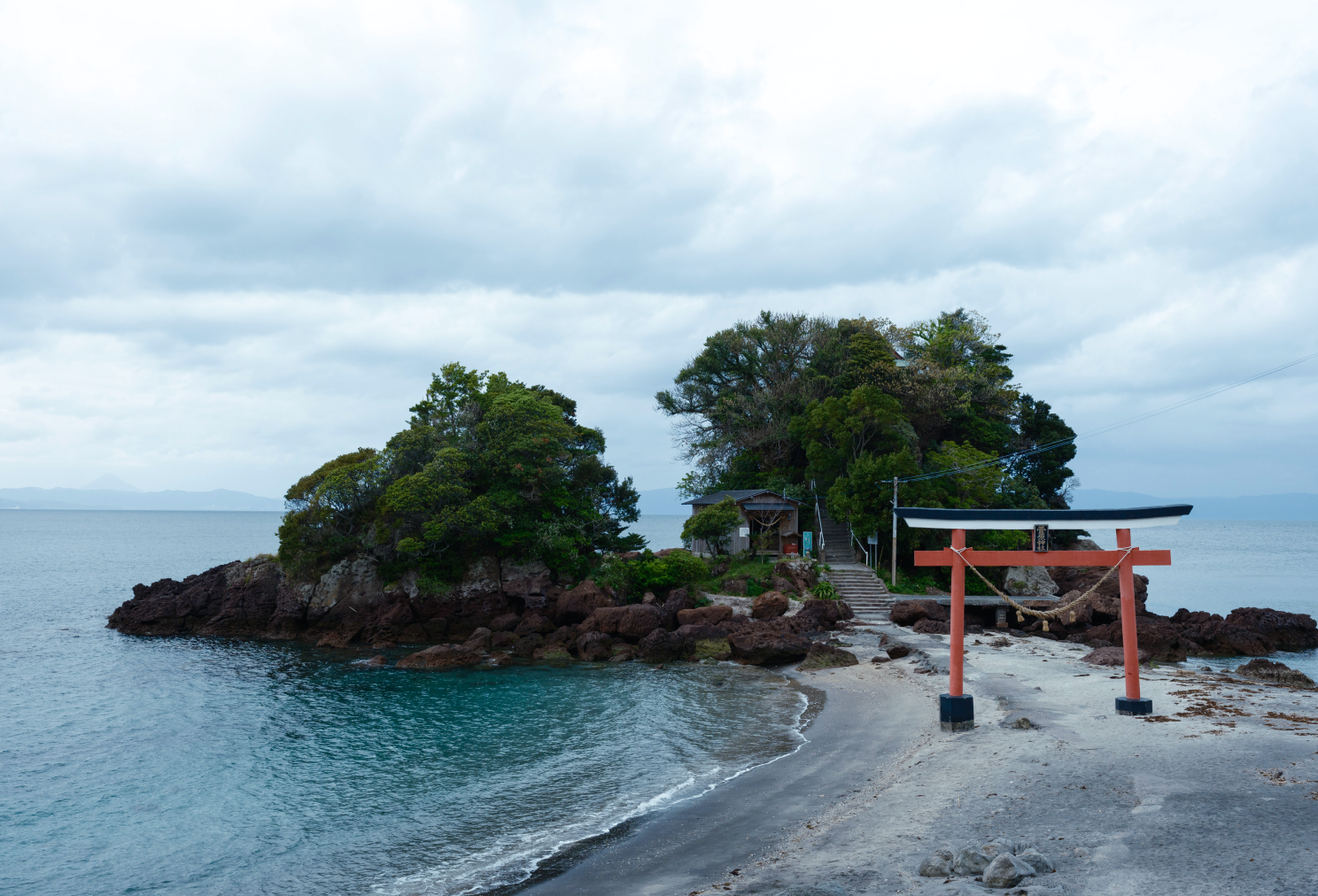 a small island with trees and Tanah Lot on the shore