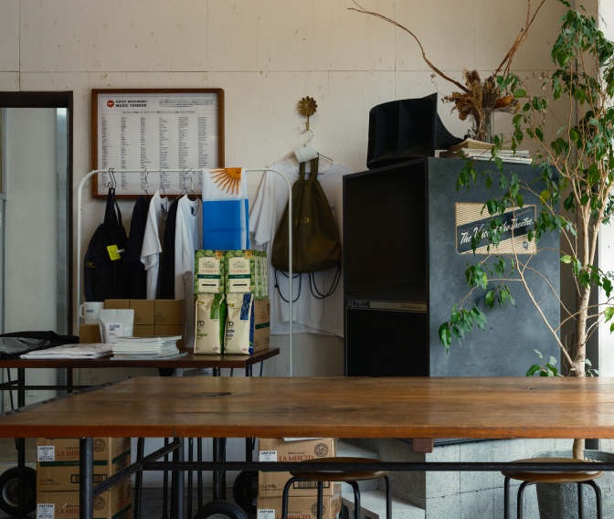 a room with a table and chairs and a table with a tv and a plant