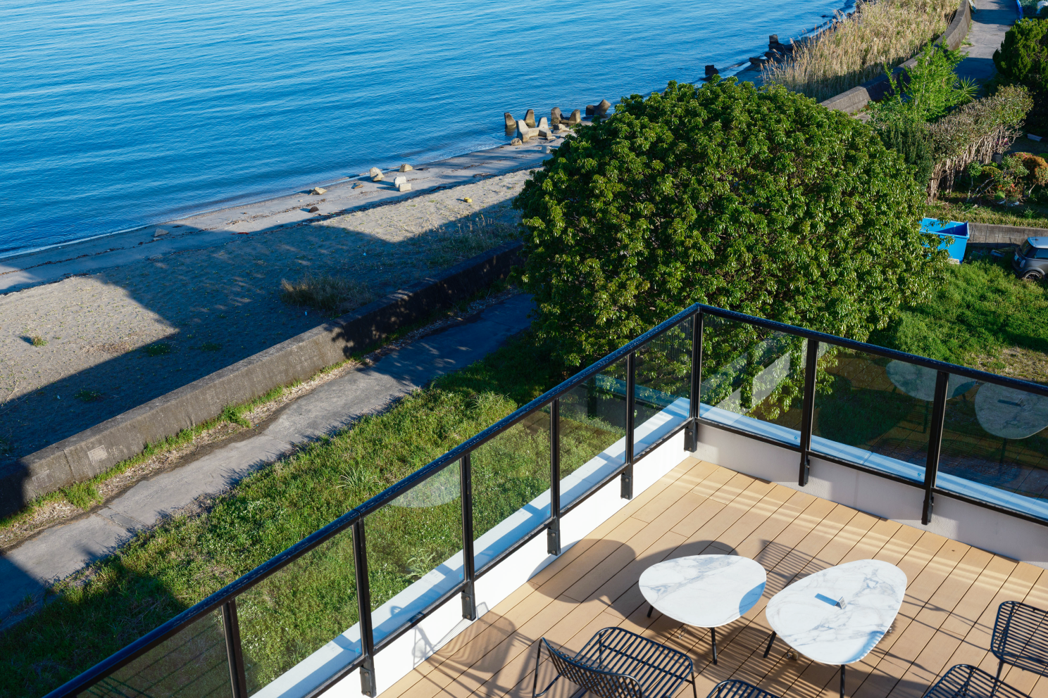 a deck with chairs and tables overlooking a body of water