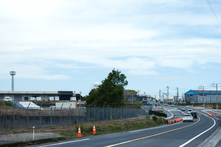 a road with orange cones and a fence