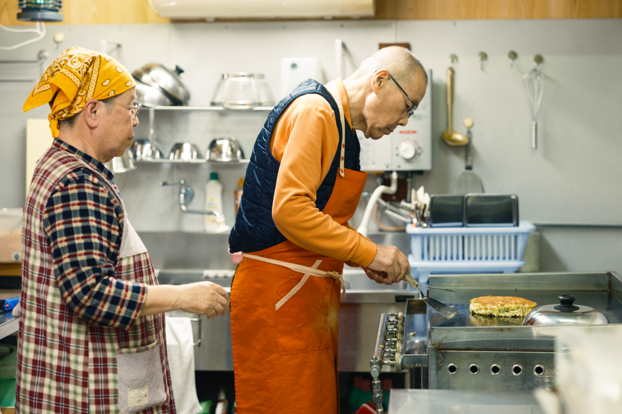 a man in an orange apron cooking food