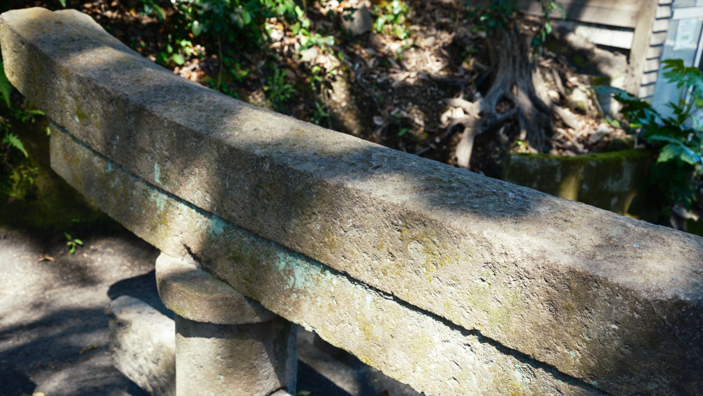 a stone railing with moss on it