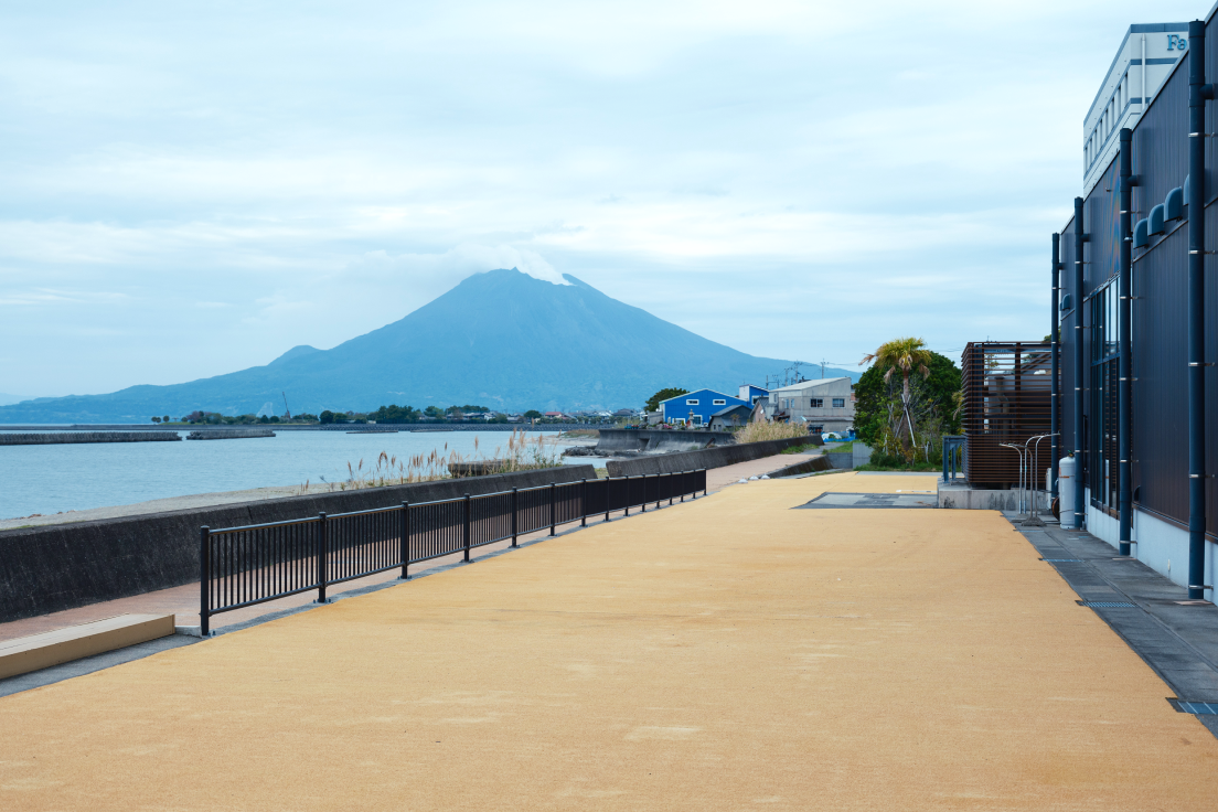 a walkway with a fence and a mountain in the background