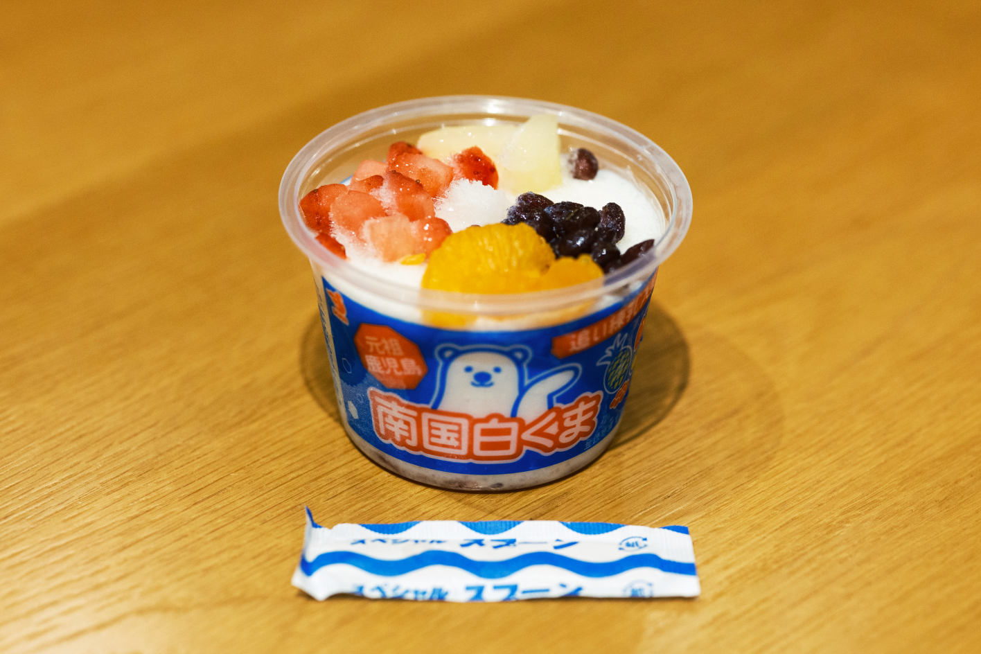 a bowl of ice cream with fruit and a packet of sugar