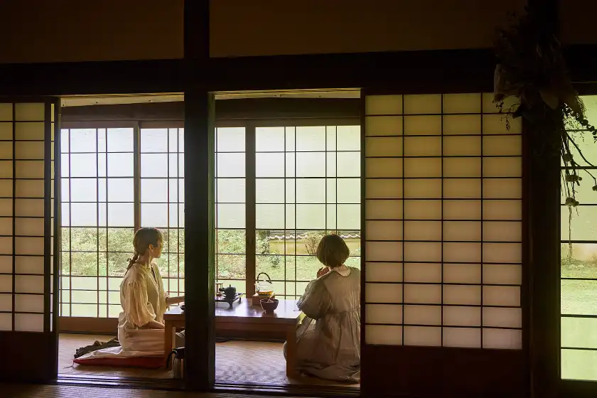 two women sitting on a window sill