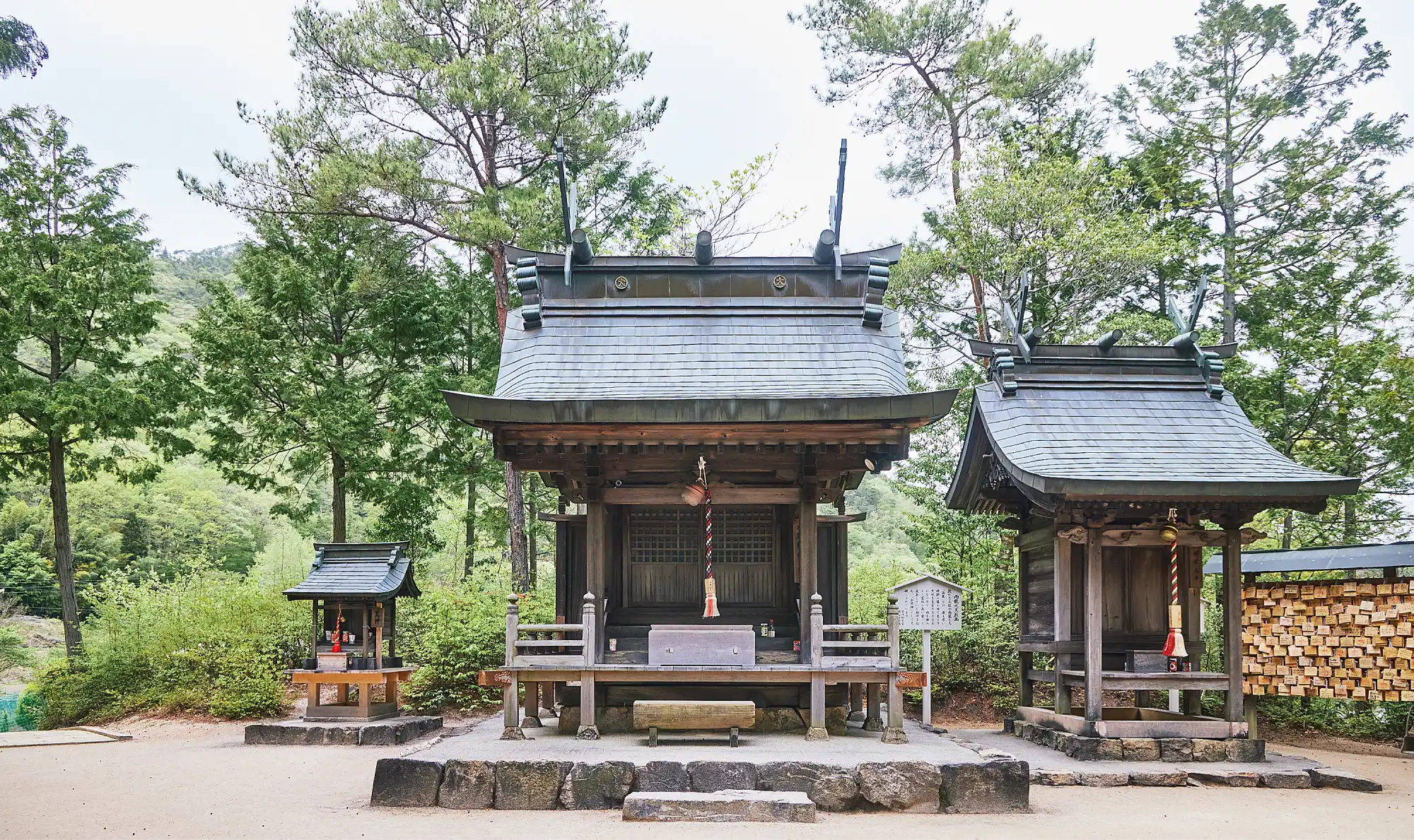a small wooden building with trees in the background