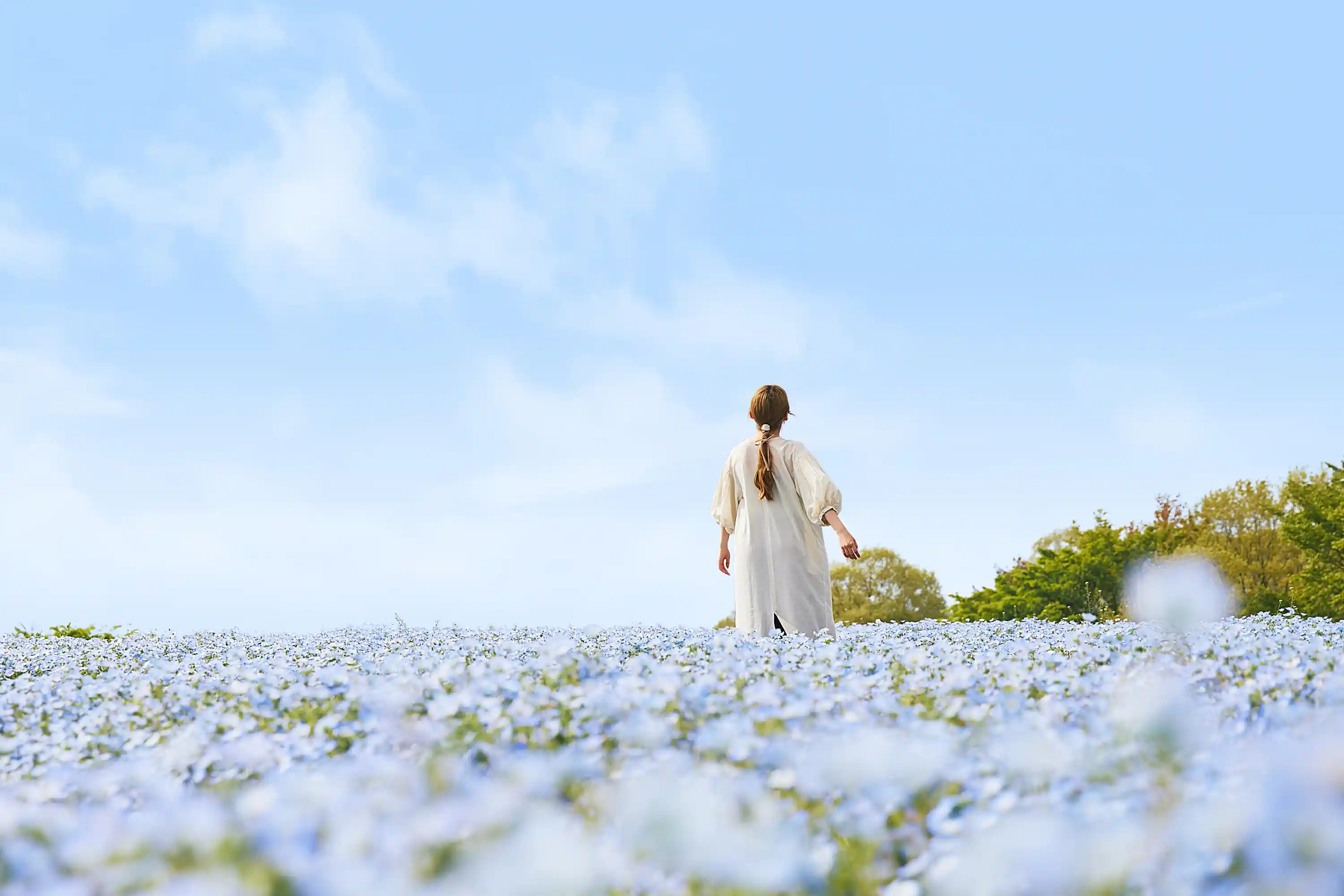 a woman standing in a field of flowers
