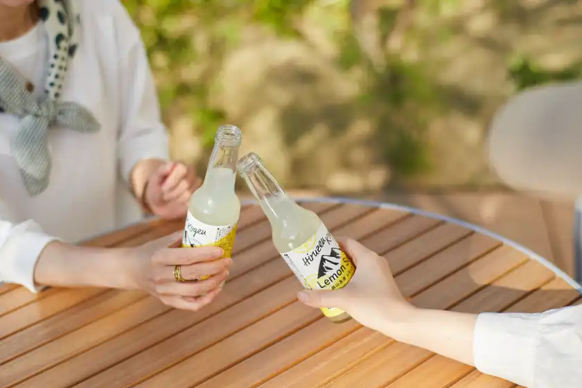 two people holding bottles of drinks