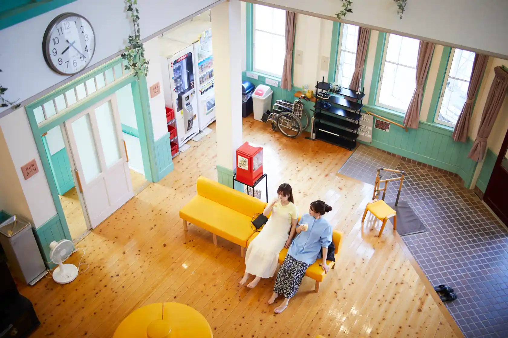 a couple of women sitting on a yellow couch in a room