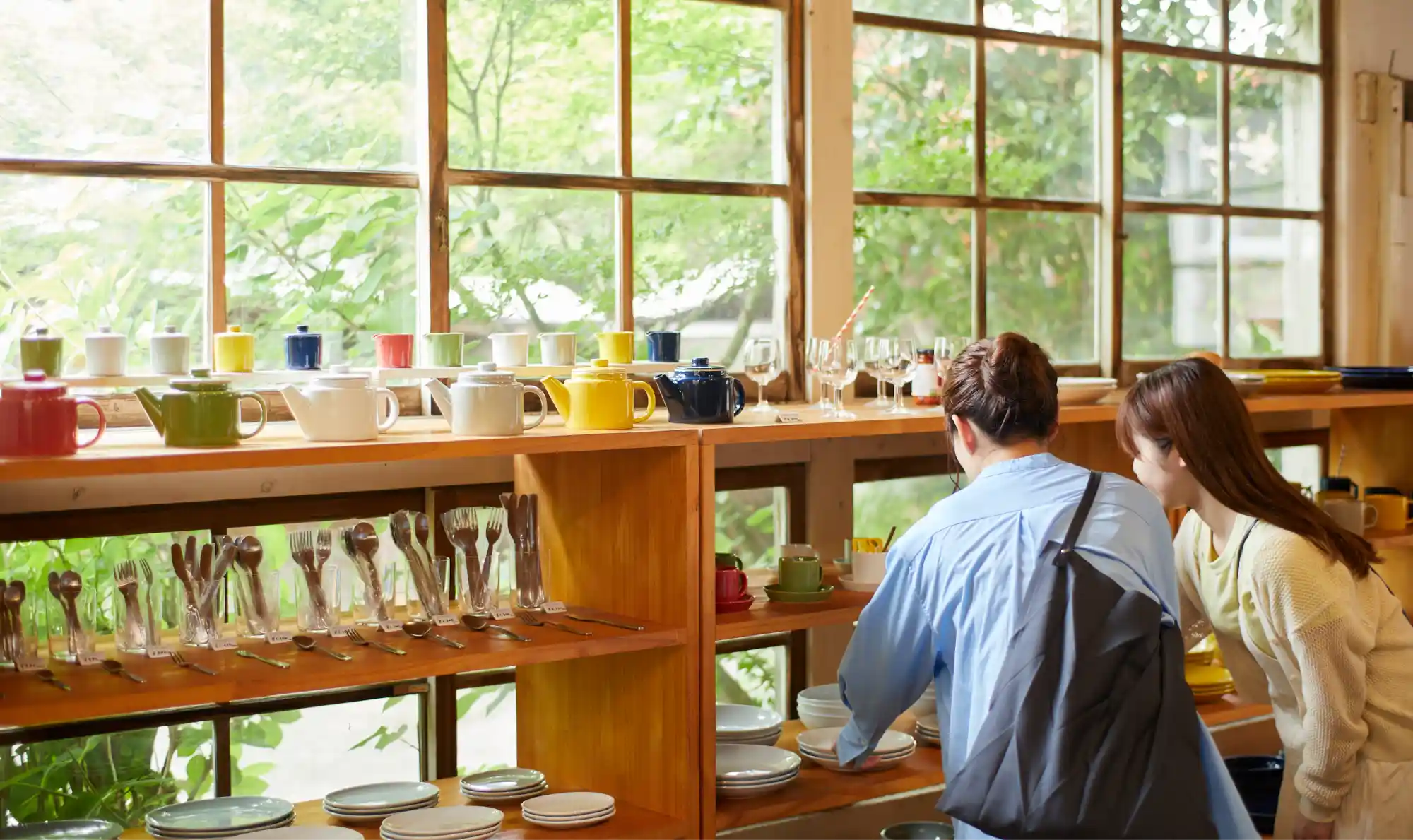 a group of people looking at dishes on shelves