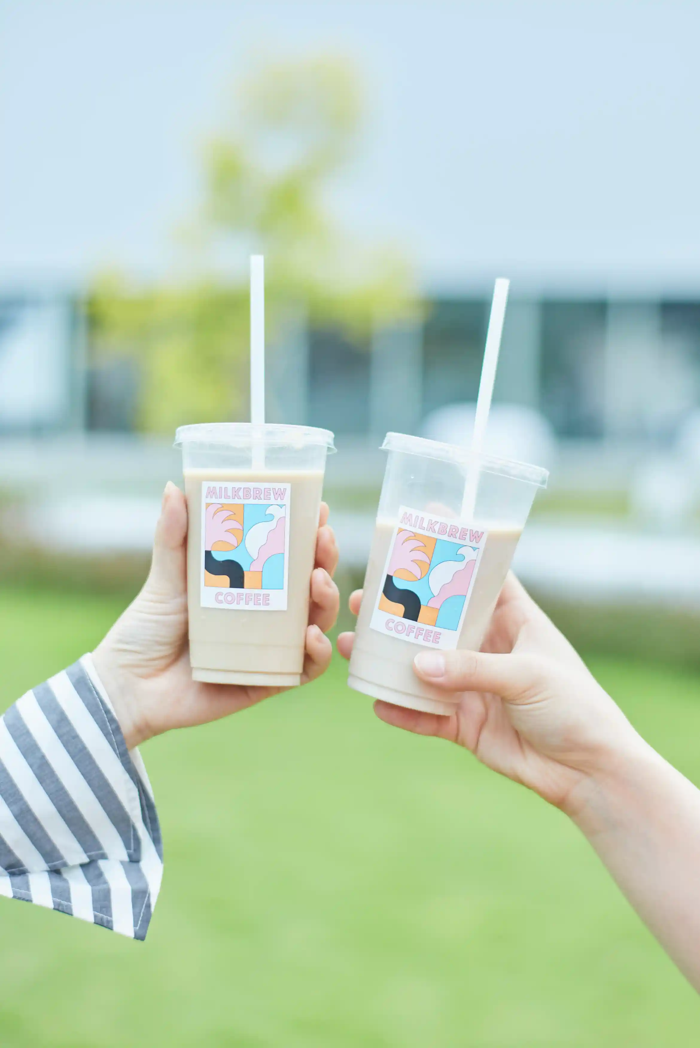 two hands holding cups of coffee