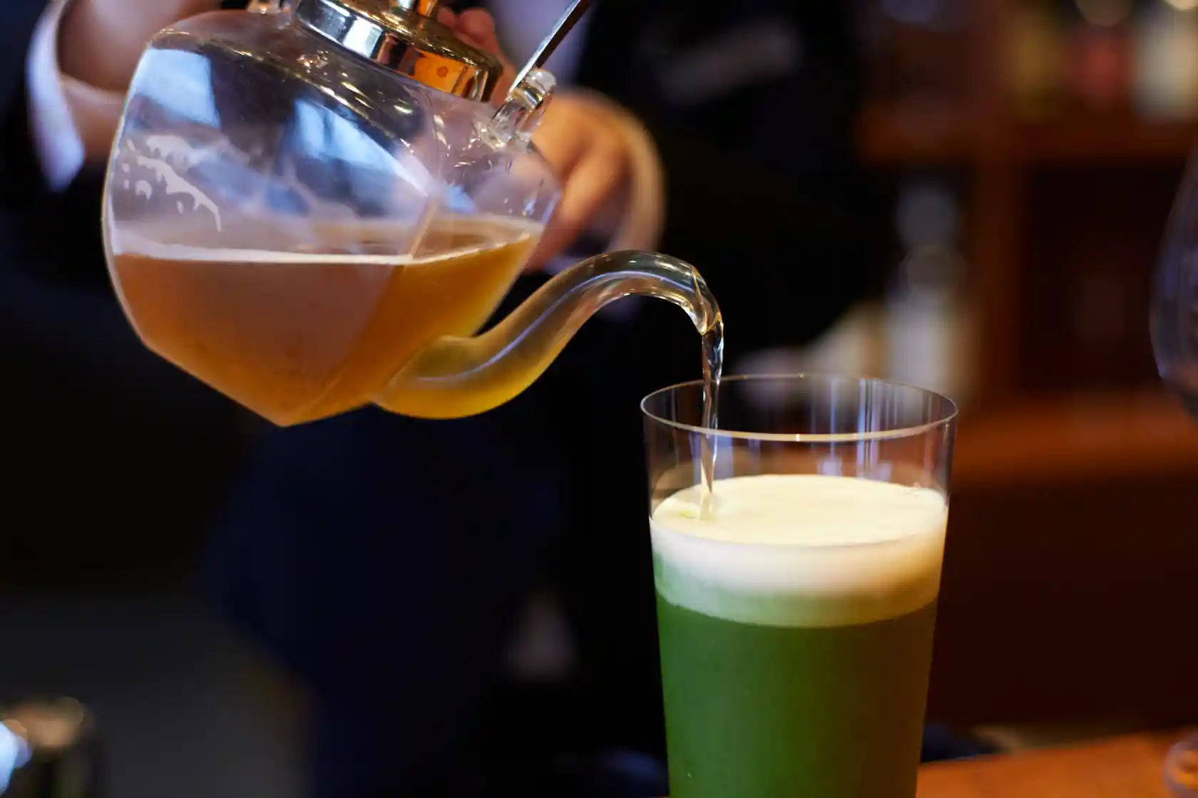 a person pouring liquid into a glass