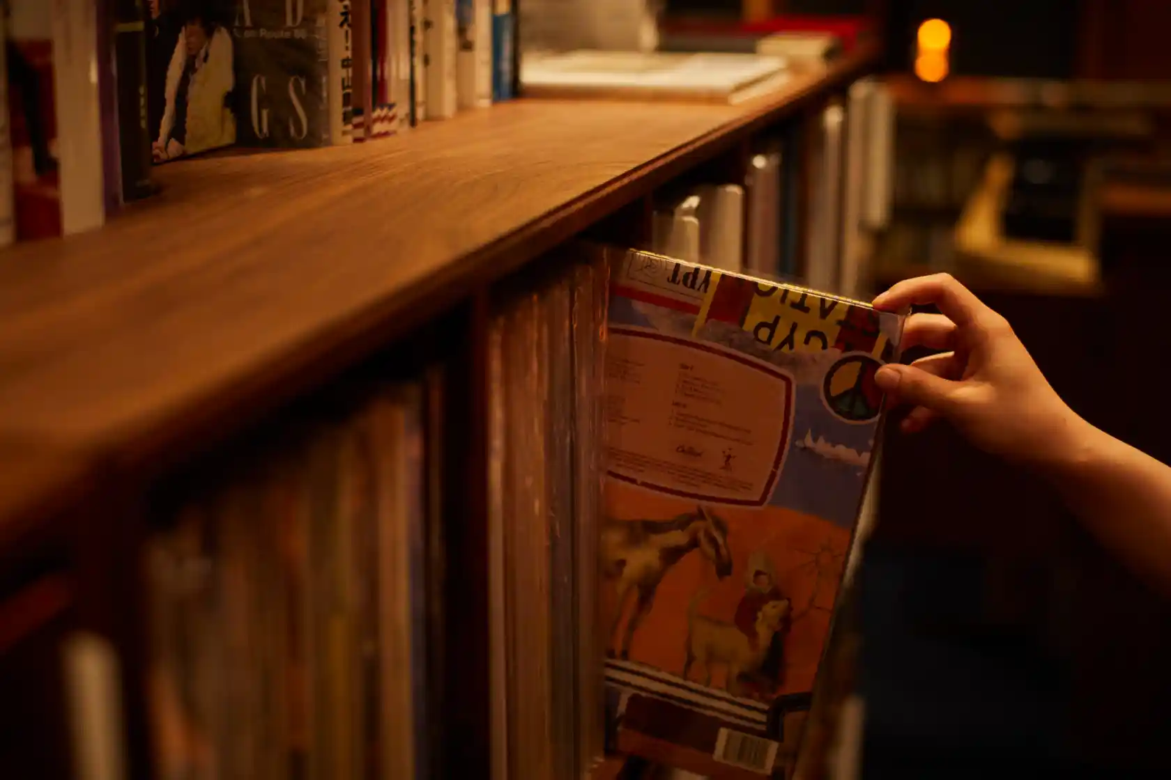 a person picking up a book from a shelf