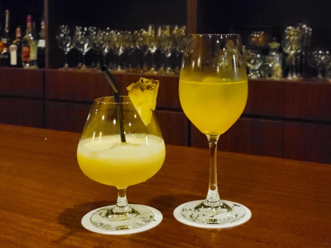 two glasses of yellow liquid on a table