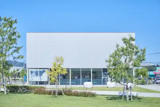 a building with glass windows and grass