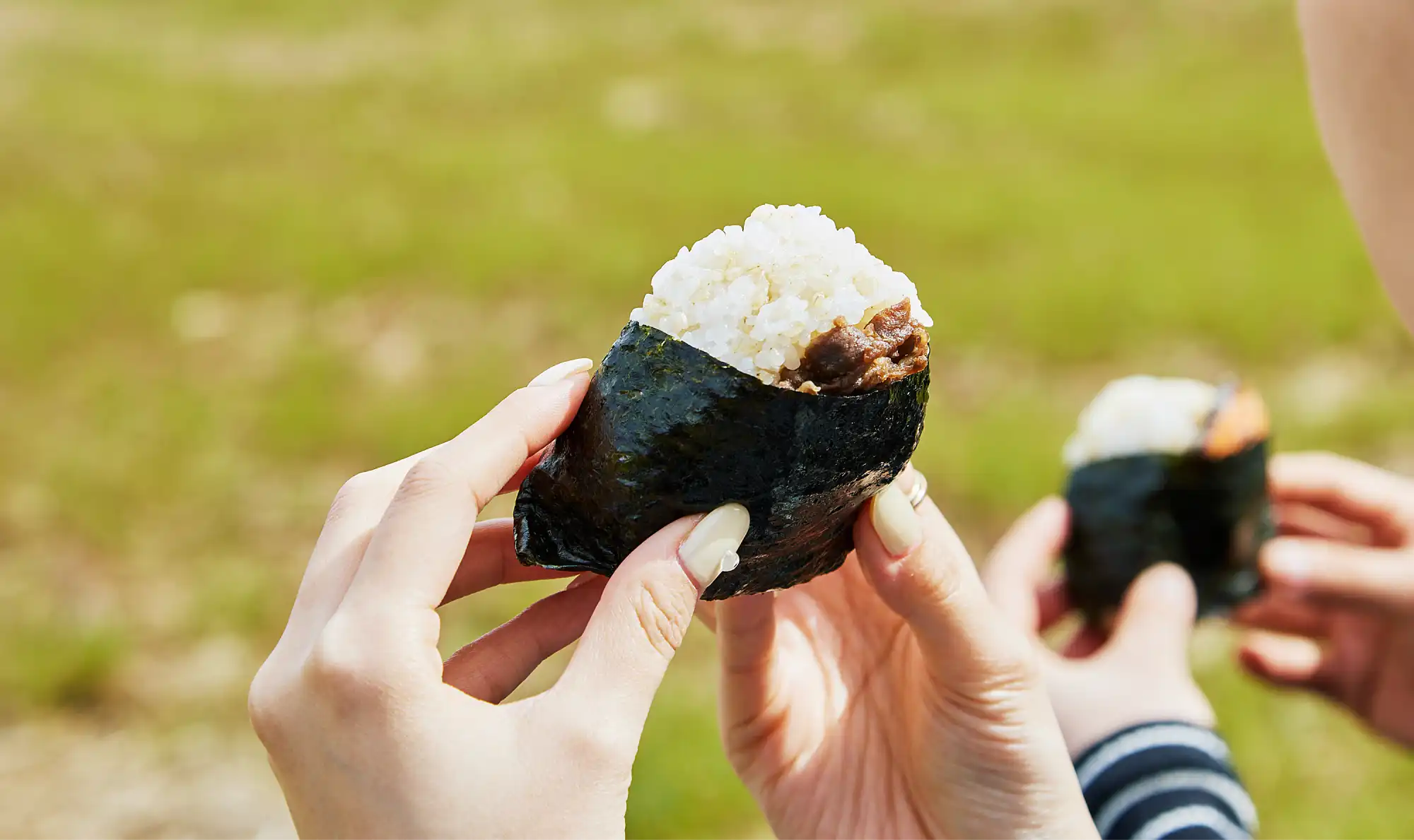 hands holding a piece of rice