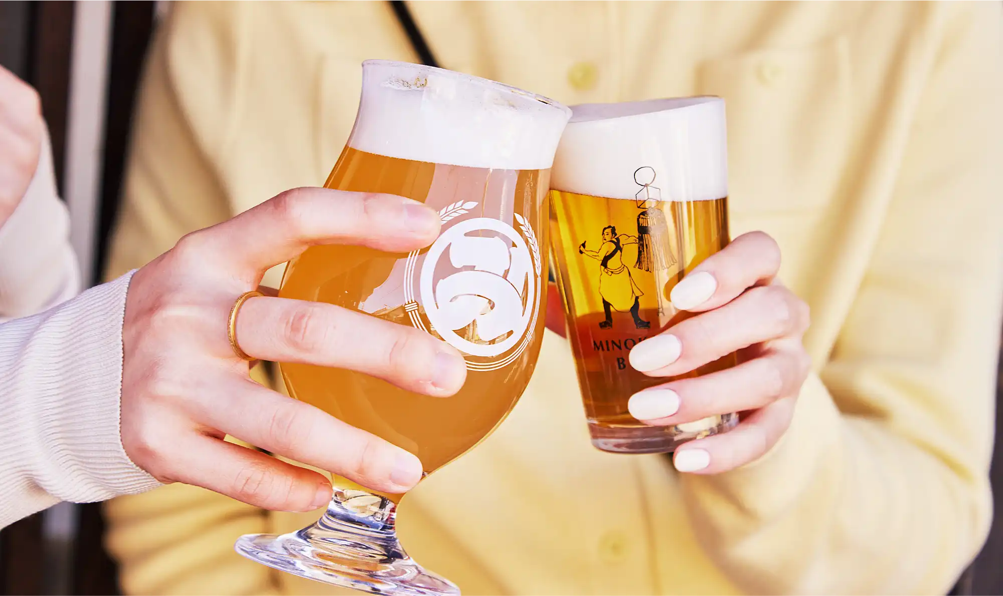 a person holding up a glass of beer