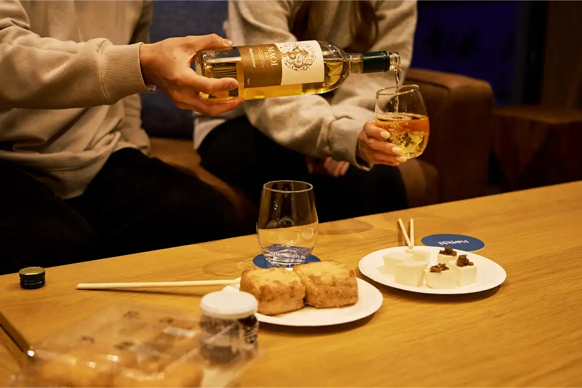 a person pouring a drink into a glass