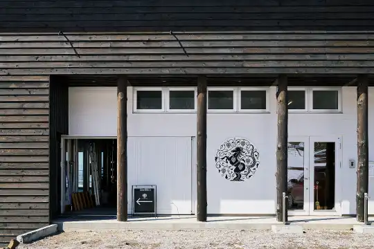 a building with a white door and a black horse on the side