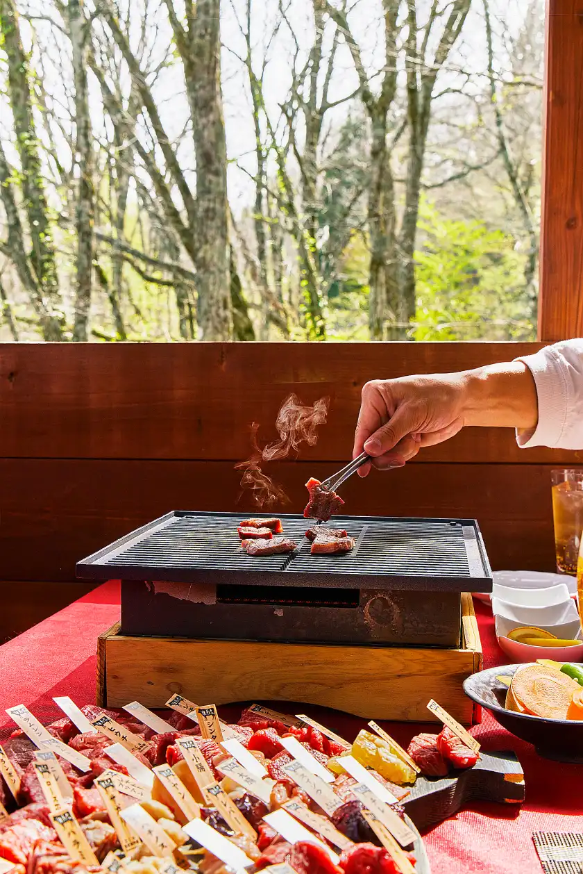 a person cooking meat on a grill