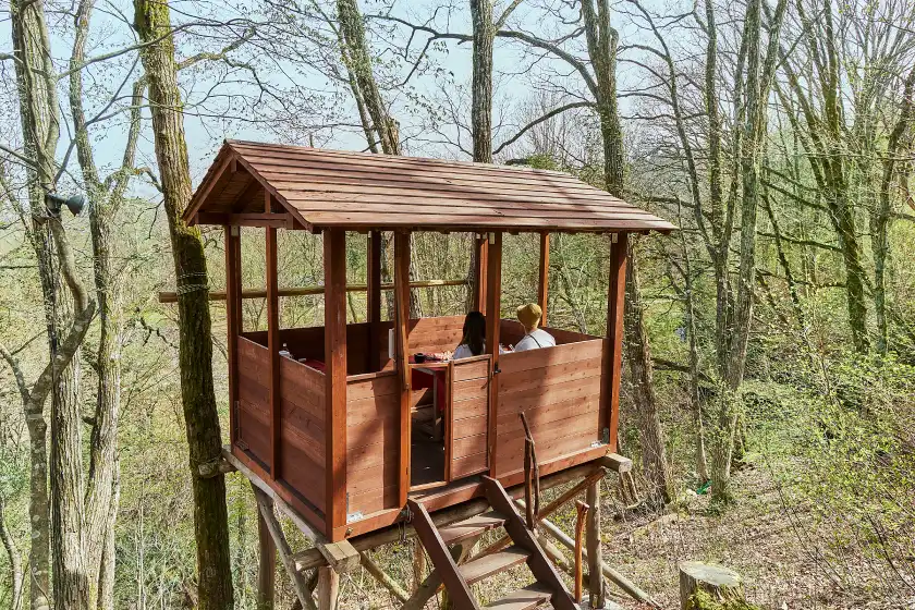 a couple of people sitting in a tree house