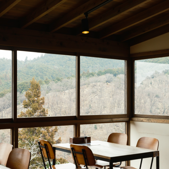 a room with a table and chairs and a view of the mountains