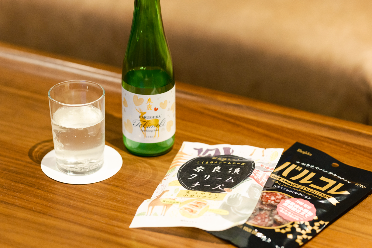 a glass of water and a bottle on a table