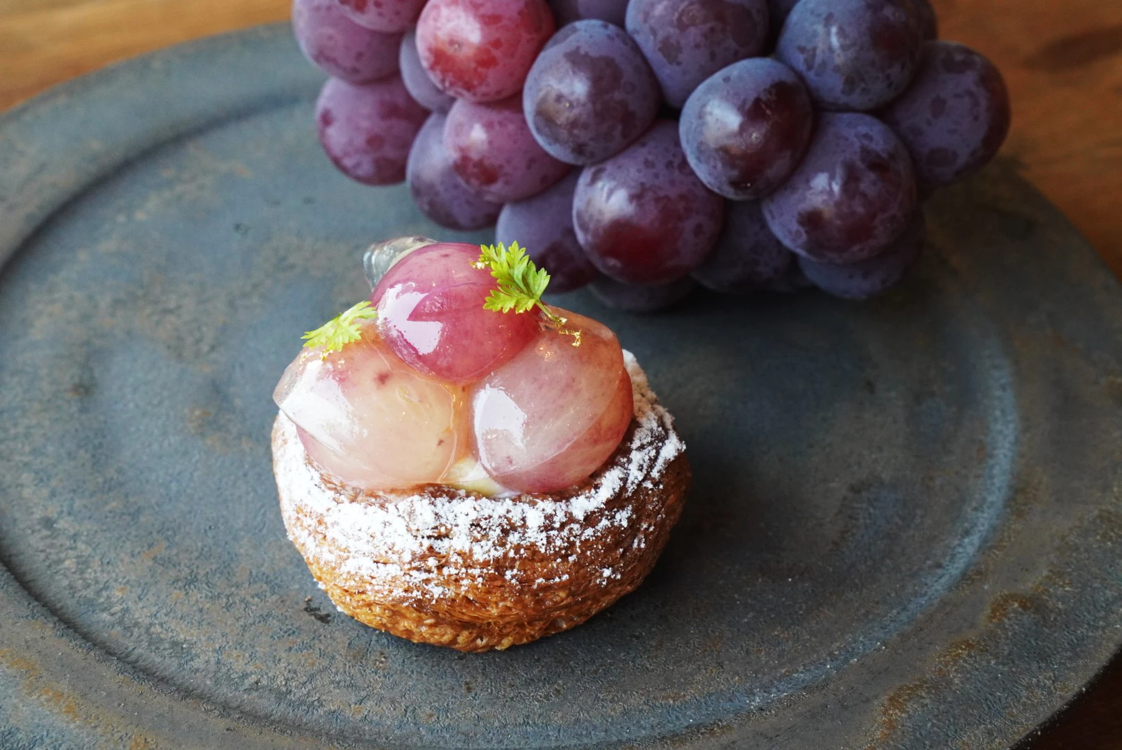 a dessert on a plate next to a bunch of grapes