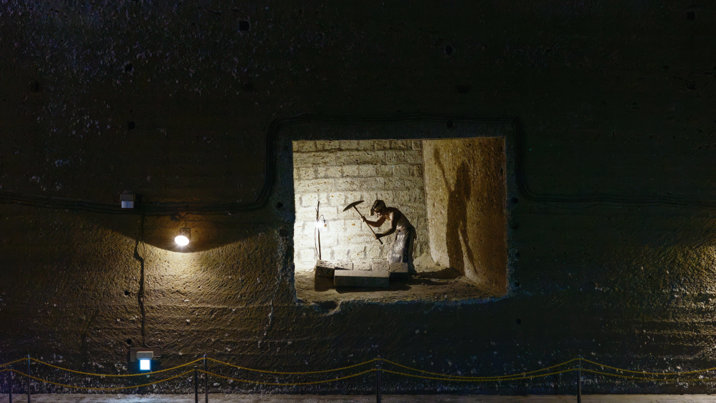a man holding a pickaxe in a brick wall