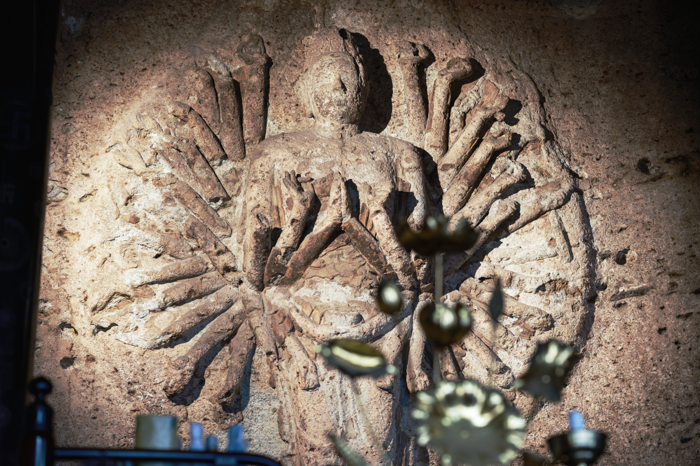 a stone carving of a person with many arms