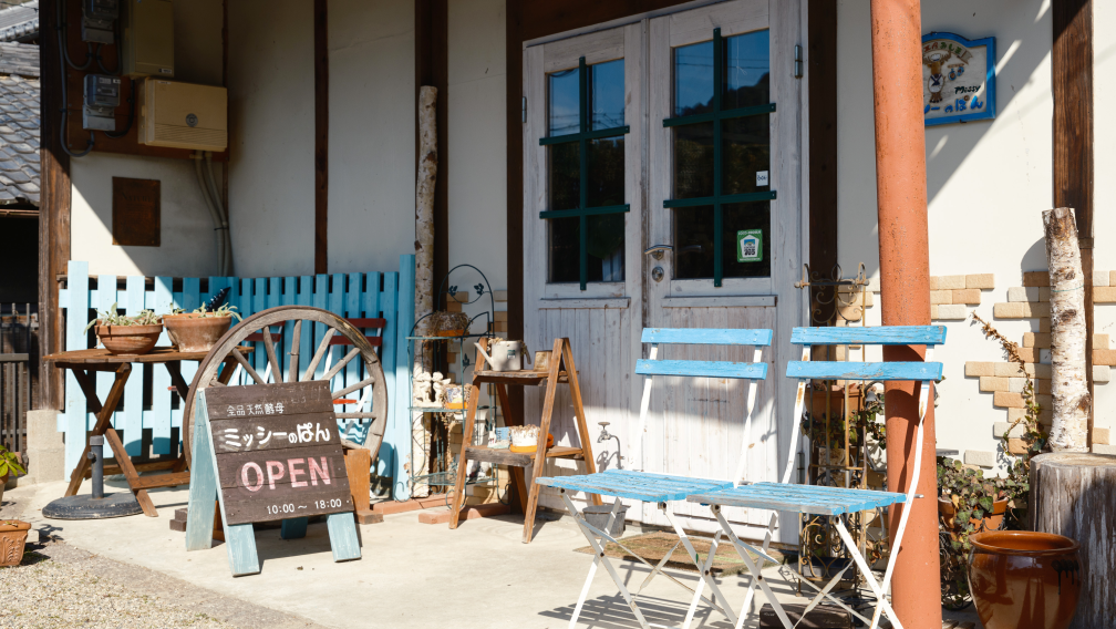 a store front with chairs and a sign