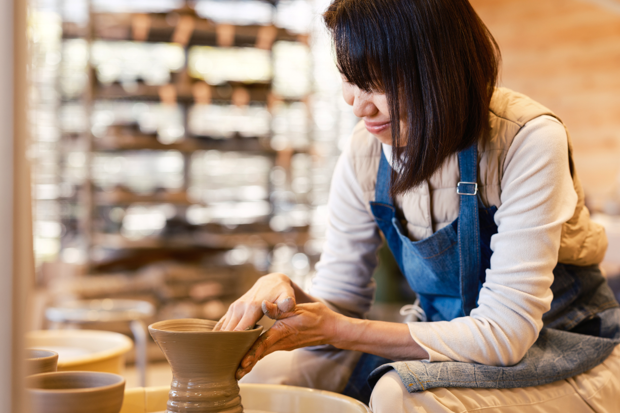 a woman making a vase
