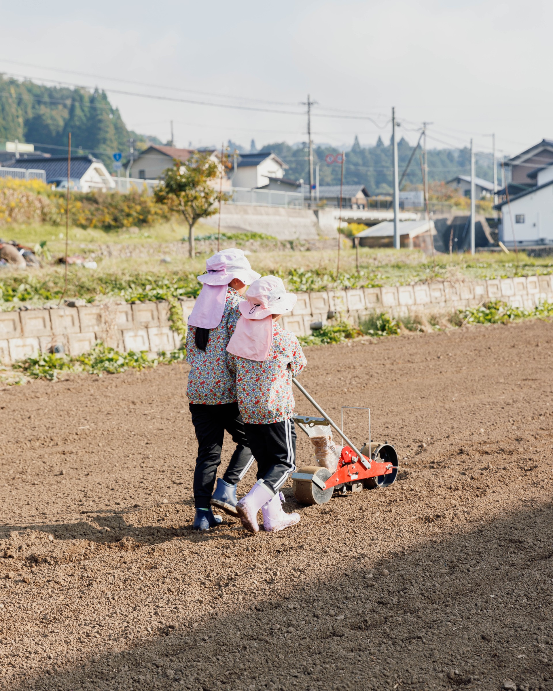 two people in hats on a dirt field