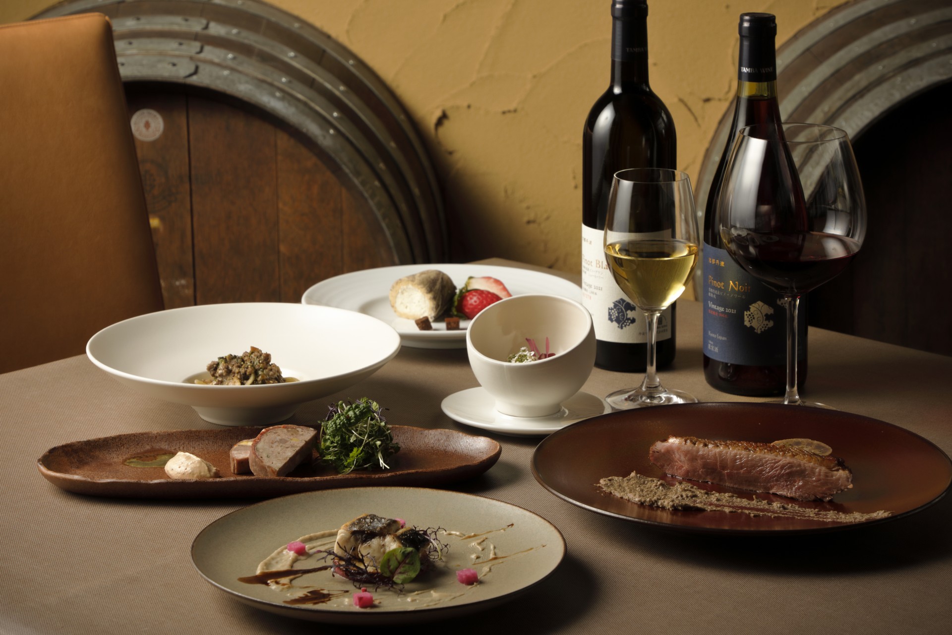 a table with plates of food and wine bottles