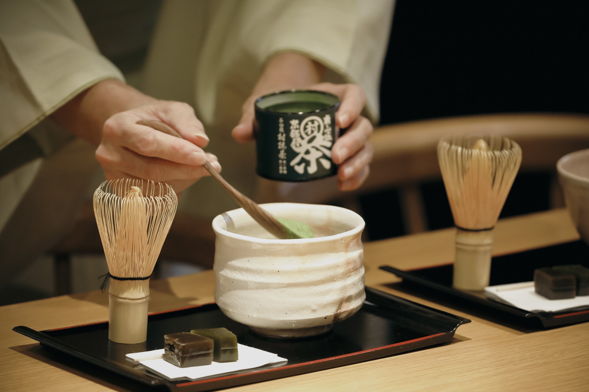 a person pouring green tea into a bowl